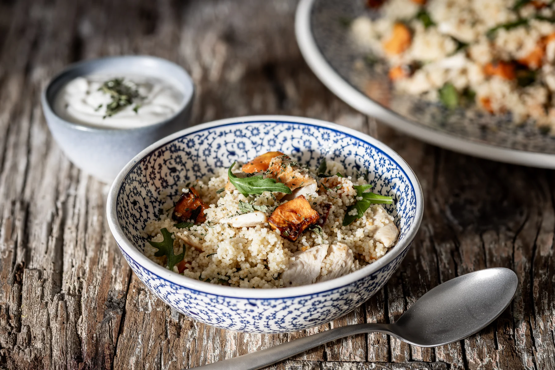 RICETTA PASTA Cous cous con zucca arrosto, pollo e tahina Modalità di preparazione: facile Tempi: circa 30 minuti + cottura zucca 20 minuti Porzioni: 4 persone Cous cous con zucca arrosto, pollo e tahina Cous cous senza glutine con zucca arrosto, pollo e rucola, completato da salsa di tahina e yogurt. Scopri la ricetta Agluten da servire tiepida o fredda. Ingredienti Ingredienti 150 gr. di cous cous senza glutine Agluten Acqua bollente o brodo vegetale 300 g. di zucca a cubetti (varietà butternut o hokkaido) 1 cucchiaio di miele Qualche foglia di salvia 350 g. di petto di pollo tagliato a cubetti Il succo e la scorza di un limone Una manciata di rucola 50 g. di tahina 80 g. di yogurt intero Poco aglio tritato (secondo il vostro gusto) 2 cucchiai di menta tritata Peperoncino Olio extra vergine d’oliva Sale e pepe Prodotto usato nella ricetta Cous cous Agluten Preparazione Preparazione della zucca:Pre-riscaldare il forno a 200°; Foderare una teglia con carta da forno; sistemare la zucca a cubetti, le foglie di salvia intere, il miele, un pizzico di sale e pepe e due cucchiai d’olio extra vergine d’oliva; Mescolare bene la zucca utilizzando le mani, infornare per circa 20 minuti , alla fine dovrà essere morbida e dorata. Preparazione del pollo:Mettere il petto di pollo in una terrina, condire con un cucchiaio di olio extra vergine d’oliva, sale, pepe, la buccia ed il succo di mezzo limone; mescolare bene, coprire con pellicola e lasciare da parte per circa 20 minuti; Trascorso questo tempo scaldare un filo d’olio extra vergine d’oliva in una padella dal fondo pesante e far dorare bene i cubetti di pollo su tutti i lati; Preparazione del cous cous:Versare il cous cous in una ciotola capace; unire due cucchiai di olio extra vergine d’oliva ed un pizzico di sale. Mescolare con una forchetta per distribuire bene l’olio; Versare acqua calda salata o brodo caldo fino a superare il livello del cous cous di mezzo centimetro. Coprire la ciotola perfettamente con una pellicola ed aspettare 10 minuti; Trascorso questo tempo mescolare il cous cous con la punta della forchetta, sgranarlo bene e verificare che sia cotto; eventualmente aggiungere ancora poca acqua calda e coprire nuovamente; Per la salsa:In una ciotola mescolare la tahina, lo yogurt, l’aglio tritato, la menta ed il succo di limone; regolare di sale e pepe. Aggiungere il peperoncino se previsto. Assemblaggio:In una ciotola capiente unire il cous cous, la zucca, il pollo e la rucola; mescolare bene tutti gli ingredienti e completare con un filo d’olio. Il cous cous può essere servito tiepido o freddo, completandolo con la salsa Consigli se il cous cous viene preparato in anticipo unire tutti gli ingredienti tranne la rucola e la salsa di tahina. Conservare in frigo ben coperto con pellicola alimentare. Prima di servire aggiungere la rucola e mescolare bene. Servire con salsa a parte.