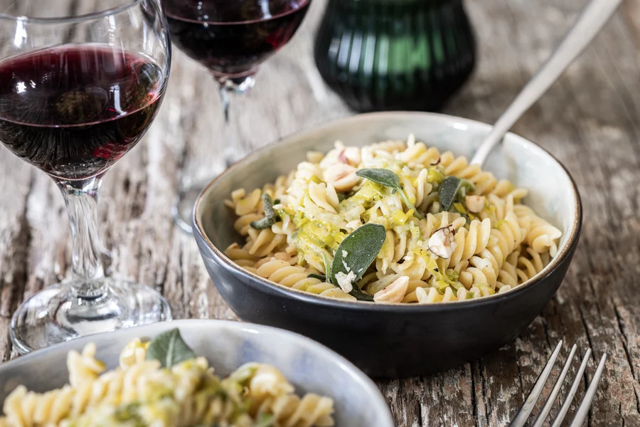 Dettaglio dei fusilli con porri, nocciole e salvia fritta in una ciotola