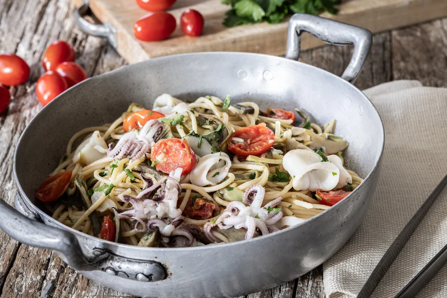 Padella di spaghetti con calamari a striscioline, carciofi e pomodorini